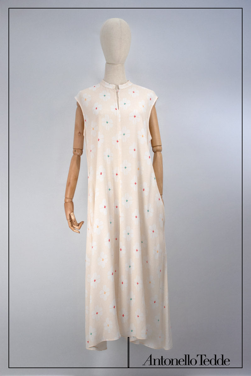 On model front view of the Long Sleeveless Dress with Mandarin Collar, crafted from a premium blend of 100% Viscose with digital prints. Designed for versatility and elegance, this dress comes in a timeless soft flower digital print with striking centre decorations in RED, GREEN or ORANGE.