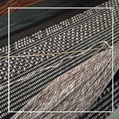 the fabric in the making on the loom for MELANGE BROWN and BLACK base bucket bag to complete your look with our selection of accessories crafted with the environment in mind