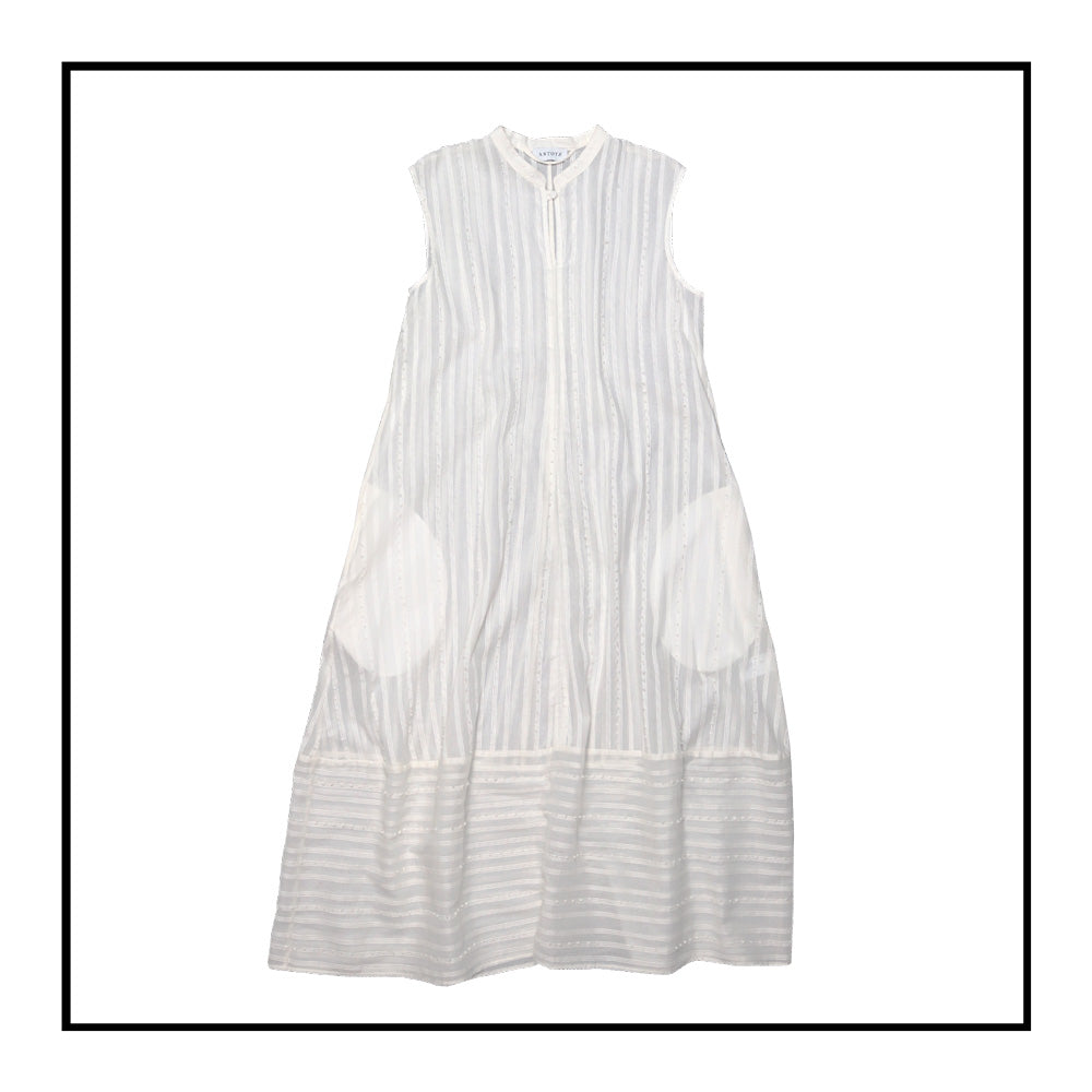 Cream sleeveless dress with a standing collar, crafted from 100% Khadi cotton handwoven in India, featuring a flowing design with hidden pockets and a matching belt for versatile styling.