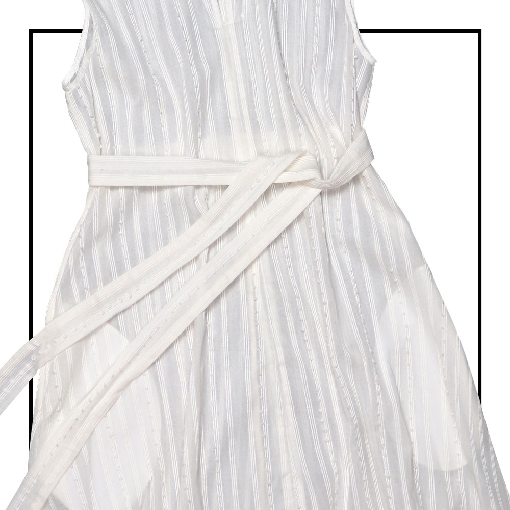 Cream sleeveless dress with a standing collar, crafted from 100% Khadi cotton handwoven in India, featuring a flowing design with hidden pockets and a matching belt for versatile styling.