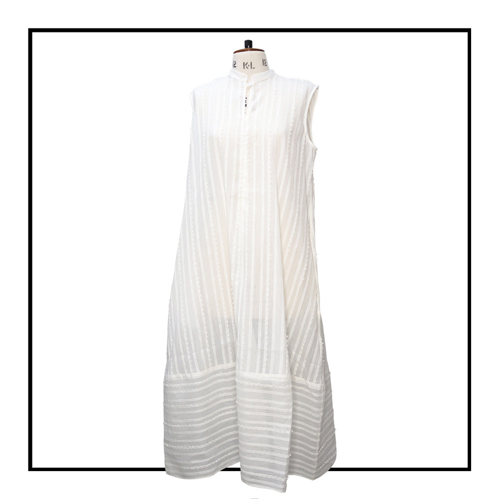 Cream sleeveless dress with a standing collar, crafted from 100% Khadi cotton handwoven in India, featuring a flowing design with hidden pockets and a matching belt for versatile styling.