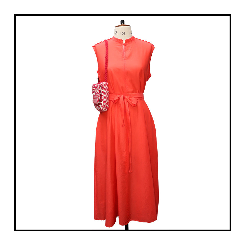 Tailor Mannequin IT 44 — UK 12 — US 8 — FR 40 front view with a red long sleeveless dress with a standing collar, made from 80% cotton and 20% silk, featuring Antonello Tedde's signature pom details, a flowing design, hidden pockets, and a matching belt.