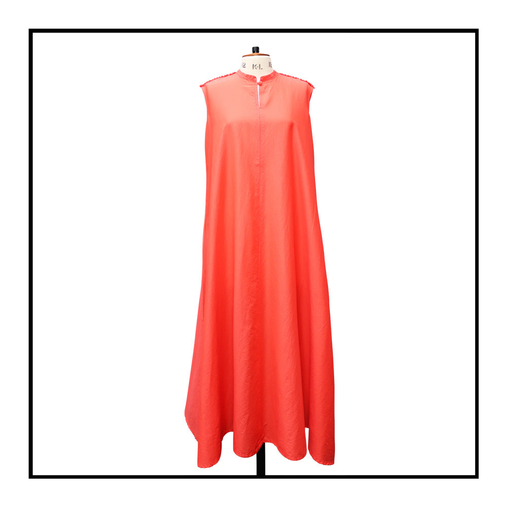 Tailor Mannequin IT 44 — UK 12 — US 8 — FR 40 front view with no belt of a red long sleeveless dress with a standing collar, made from 80% cotton and 20% silk, featuring Antonello Tedde's signature pom details, a flowing design, hidden pockets, and a matching belt.