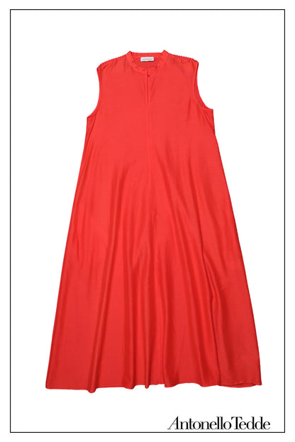 Front view without the belt of an elegant red long sleeveless dress with a standing collar, crafted from 80% cotton and 20% silk, featuring Antonello Tedde's distinctive pom detail design, a flowing silhouette, hidden pockets, and a matching belt for versatile styling.