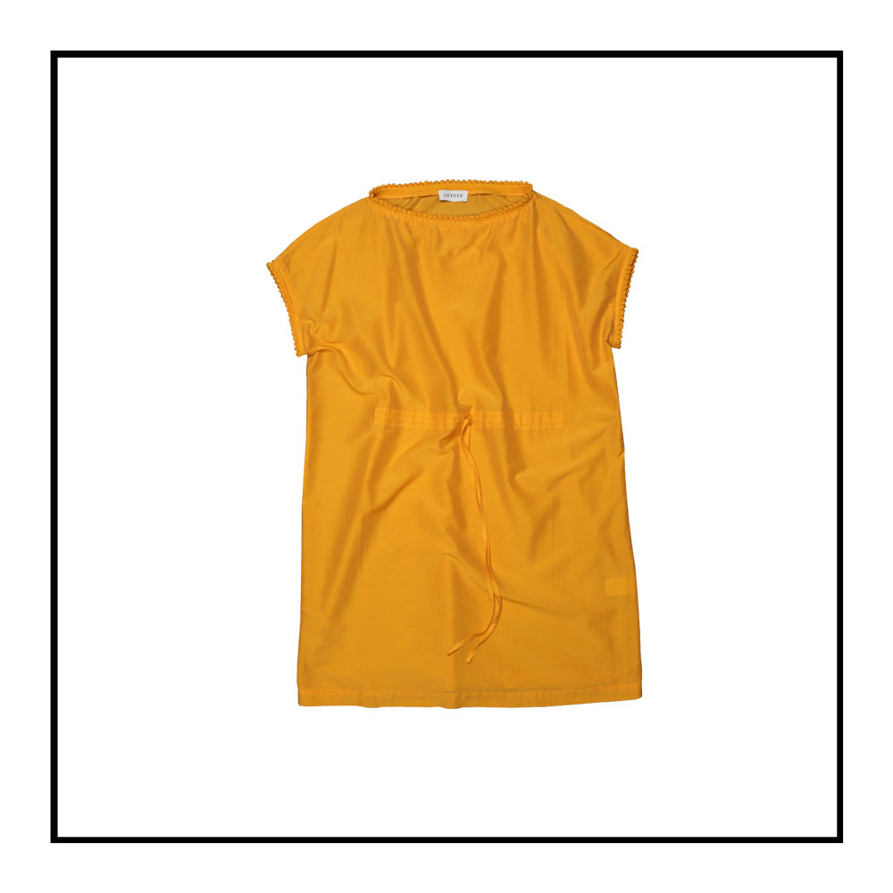 Mustard yellow cover-up dress with round collar, pom details on the collar and sleeve edges, adjustable drawstring waist belt, crafted from 80% cotton and 20% silk, designed for lightweight comfort and elegance.