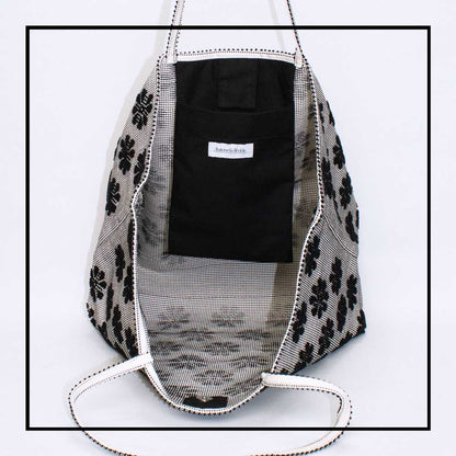 Inside view - pocket view of a black and white tote bag with a daisies pattern. Main view of our Sustainable tote - summer bag - luxury handbag - handwoven made in Italy by hand  - timeless individualistic fashion • eco-friendly fashion • socially responsible, lasting fashion.