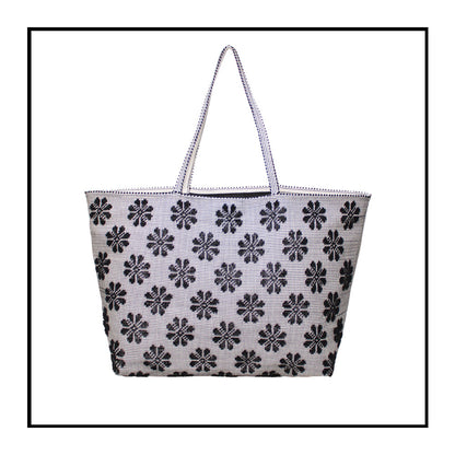 Front view of a black and white tote bag with a daisies pattern. Main view of our Sustainable tote - summer bag - luxury handbag - handwoven made in Italy by hand  - timeless individualistic fashion • eco-friendly fashion • socially responsible, lasting fashion.