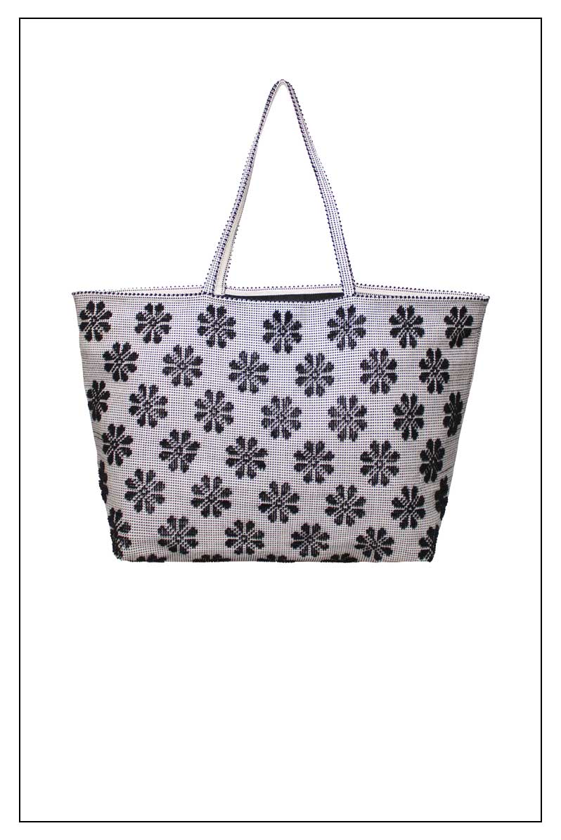 Front view of a black and white tote bag with a daisies pattern. Main view of our Sustainable tote - summer bag - luxury handbag - handwoven made in Italy by hand  - timeless individualistic fashion • eco-friendly fashion • socially responsible, lasting fashion.