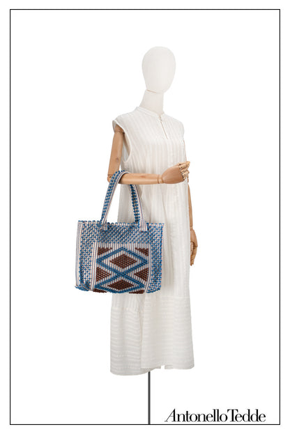 Cream sleeveless dress with a standing collar on a model and styled with bag, crafted from 100% Khadi cotton handwoven in India, featuring a flowing design with hidden pockets and a matching belt for versatile styling.