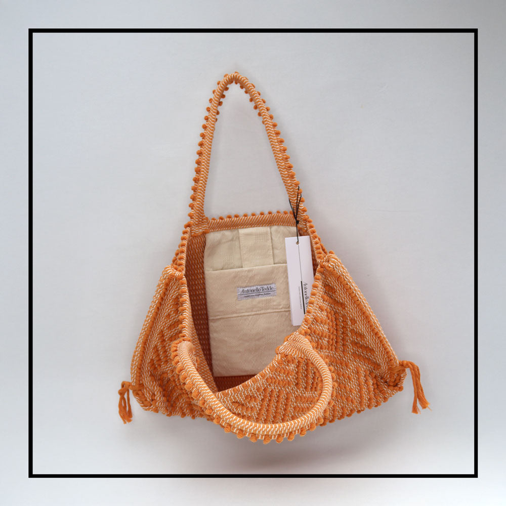 Capriccioli Medium orange with zig zag pattern - The bag is made using authentic Sardinian hand weaving methods in ethically managed factories. This tote bag is extraordinary and evokes faraway cultures with a contemporary touch, with focus on details such as colour, and material that are sustainable and eco-conscious